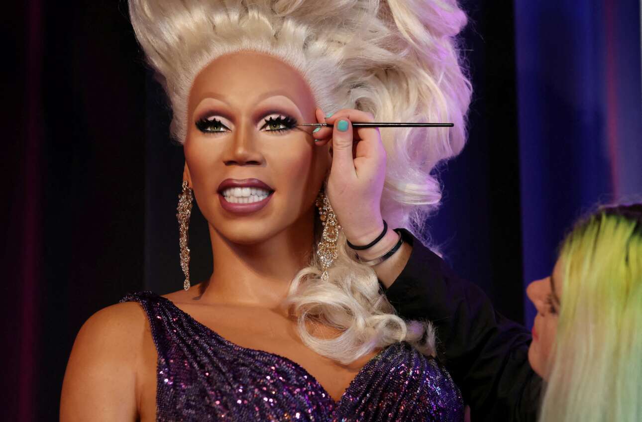 Αιωνία του η δόξα: η μακιγιέζ του μουσείου «Μαντάμ Τισό» (υποκατάστημα Μπλάκπουλ) βάζει την τελευταία πινελιά στο υπερμέγεθες κέρινο ομοίωμα του παρενδυτικού («drag queen») RuPaul – το εν λόγω άτομο, αμερικανικής υπηκοότητας, τυγχάνει τηλεπερσόνα, μοντέλο και καλλιτέχνης ηχογραφήσεων, διάσημος στον αγγλοσαξονικό κόσμο  