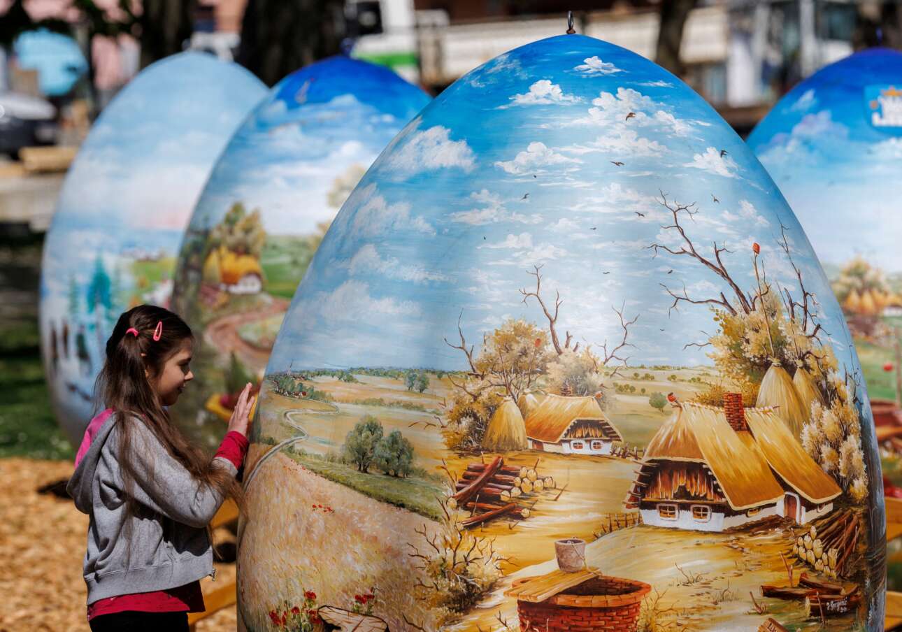 Στην Κοπρίβνιτσα, στον Βορρά της Κροατίας, ένα κορίτσι περιεργάζεται δίμετρα πασχαλινά αυγά φτιαγμένα από πολυεστέρα και ζωγραφισμένα με ναΐφ παραστάσεις μιας παραμυθένιας πια αγροτικής ζωής – τα συγκεκριμένα καλλιτεχνήματα προορίζονται να στολίσουν δημόσιους χώρους αυτήν την περίοδο, σε όλη τη χώρα 